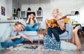 Family at living room together. Father playing chess with little son, mother learning online using laptop, older son playing Royalty Free Stock Photo