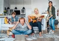 Family at living room together Quarantine time. Father distance working using laptop, mother cleaning the room, older son playing Royalty Free Stock Photo