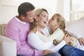 Family in living room with young girl kissing woma