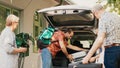 Family loading voyage baggage and trolleys inside car trunk Royalty Free Stock Photo