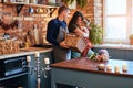 Family in loft style kitchen at morning. Father holds a basket with flowers while mother hugging with her little