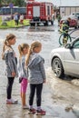 Three little girls looking at an aftermath of torrential rain