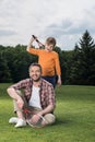 Family looking at camera while resting after badminton game outdoors Royalty Free Stock Photo