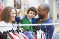 Family Looking At Clothes On Rail In Shopping Mall Royalty Free Stock Photo