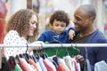 Family Looking At Clothes On Rail In Shopping Mall Royalty Free Stock Photo