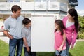 Family looking at a empty board outside house Royalty Free Stock Photo