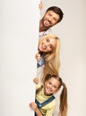 Family Looking Out Of Empty White Board, Studio Background Royalty Free Stock Photo