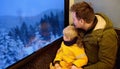 Family looking out of the window of train during travel on cogwheel railway/rack railway in Alps mountains