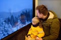 Family looking out of the window of train during travel on cogwheel railway/rack railway in Alps mountains