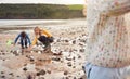 Family Looking In Rockpools On Winter Beach Vacation Royalty Free Stock Photo