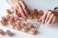 Family Lotto board game. The hands of an elderly woman put the barrels on the cards