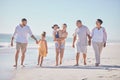 Family, love and beach with a girl, grandparents and parents walking on the sand with a view of the sea or ocean and sky Royalty Free Stock Photo