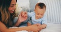 Family, love and a mother on the bed with her baby in their home together for care or bonding. Children, smile and a Royalty Free Stock Photo