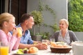 Family, lunch and happy with child on patio with conversation, relax and eating in summer at house. Parents, kid and Royalty Free Stock Photo