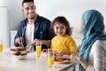 Family Lunch. Middle Eastern Parents And Little Daughter Eating Meal In Kitchen Royalty Free Stock Photo