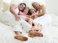 Family lying in bed smiling Royalty Free Stock Photo