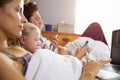 Family Lying In Bed Together Using Digital Devices Royalty Free Stock Photo