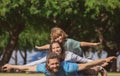 Family lying on grass in park. Parents giving child piggybacks in countryside. Fly concept, little boy is sitting Royalty Free Stock Photo