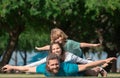 Family lying on grass in park. Parents giving child piggybacks in countryside. Fly concept, little boy is sitting