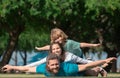 Family lying on grass in park. Parents giving child piggybacks in countryside. Fly concept, little boy is sitting Royalty Free Stock Photo