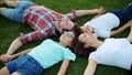 Family lying on green grass in circle. Cute kids and parents relaxing in field Royalty Free Stock Photo