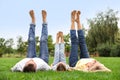 Happy family lying on green grass in park Royalty Free Stock Photo