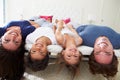 Family Lying Upside Down On Bed In Pajamas Together