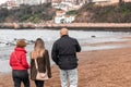 Family made up of mother, father and teenage daughter walking along the beach Royalty Free Stock Photo