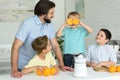 family making fresh orange juice in kitchen Royalty Free Stock Photo