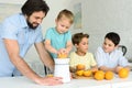 family making fresh orange juice together in kitchen Royalty Free Stock Photo