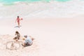 Family making sand castle at tropical white beach. Royalty Free Stock Photo