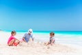 Father and little daughters making sand castle at tropical beach Royalty Free Stock Photo