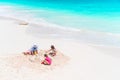 Father and little daughters making sand castle at tropical beach Royalty Free Stock Photo