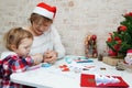 Family making seasonal greeting cards together at christmas time, grandmother with granddaughter at home Royalty Free Stock Photo