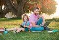 Family man business online. Father and son working on laptop remote in the park. Royalty Free Stock Photo