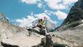 Family married couple of tourists are sitting on a rock and enjoying the mountain view. Man hugs a woman in a hike and Royalty Free Stock Photo