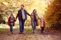 Family With Mature Parents And Two Children Holding Hands Walking Along Track In Autumn Countryside Royalty Free Stock Photo