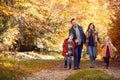 Family With Mature Parents And Two Children Holding Hands Walking Along Track In Autumn Countryside Royalty Free Stock Photo