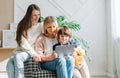 Family Mature senior woman mother with adult daughter and child kid boy using digital tablet computer device. Caucasian Royalty Free Stock Photo