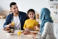 Family Meal. Happy Muslim Parents And Little Daughter Eating In Kitchen Together Royalty Free Stock Photo