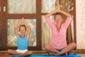 Mother and daughter doing yoga exercise outdoors