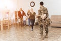 The family meets a man in camouflage at home. Royalty Free Stock Photo