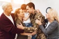 The family meets a man in camouflage at home. Royalty Free Stock Photo