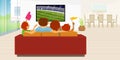 Family of 4 members sitting on a red sofa in their living room inside their house watching a soccer game on a large flat tv