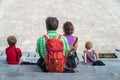 Family members sitting on square in Sapa on vacation in Vietnam. Backpack travel. Large family member