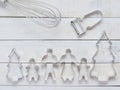 Family metal cookie or biscuit cutter composed of father, mother, brother, sister and pine tree with metal whisk and peeler over r