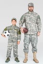 family in military uniforms holding soccer and rugby balls