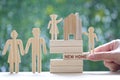 Family,Model house on wooden block with word `NEW HOME` and model family on natural green background,New home and real estate conc Royalty Free Stock Photo