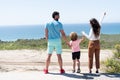 family of mom dad and child boy looking in future holding hands in summer, back view, happy family