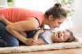 Family - mom and daughter having a fun on floor at home. Woman and child relaxing together.